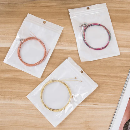 Guitar Strings in Packaging. One Gold Set, one bronze set, and one colorful set.  | Sacred Tune